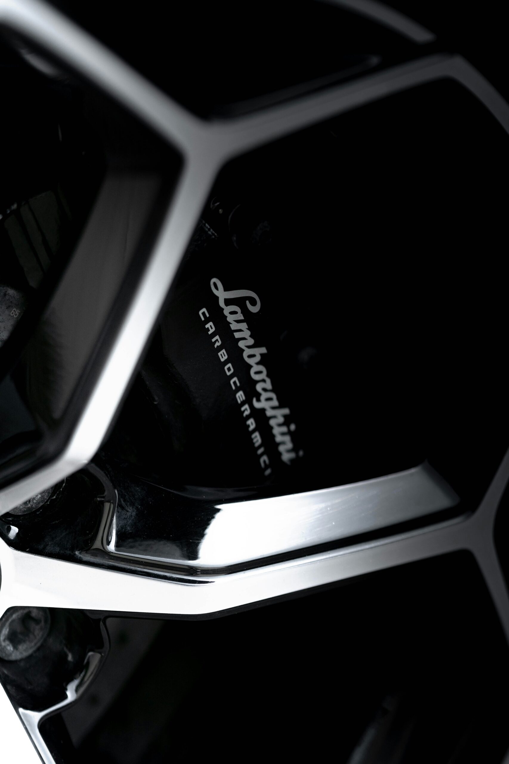 Detailed view of Lamborghini Huracán carbon ceramic brake caliper through gloss black alloy wheel — highlighting performance and luxury design.