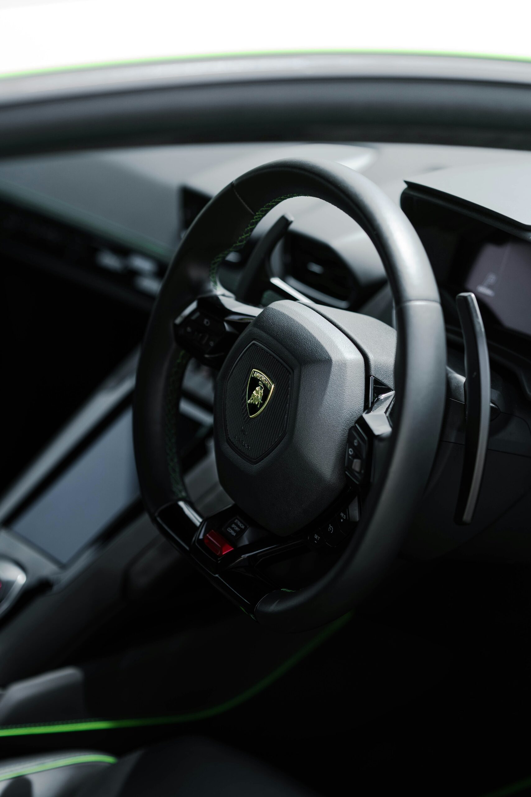 Lamborghini Huracán interior featuring leather-wrapped steering wheel, paddle shifters, and digital display — designed for performance and control.